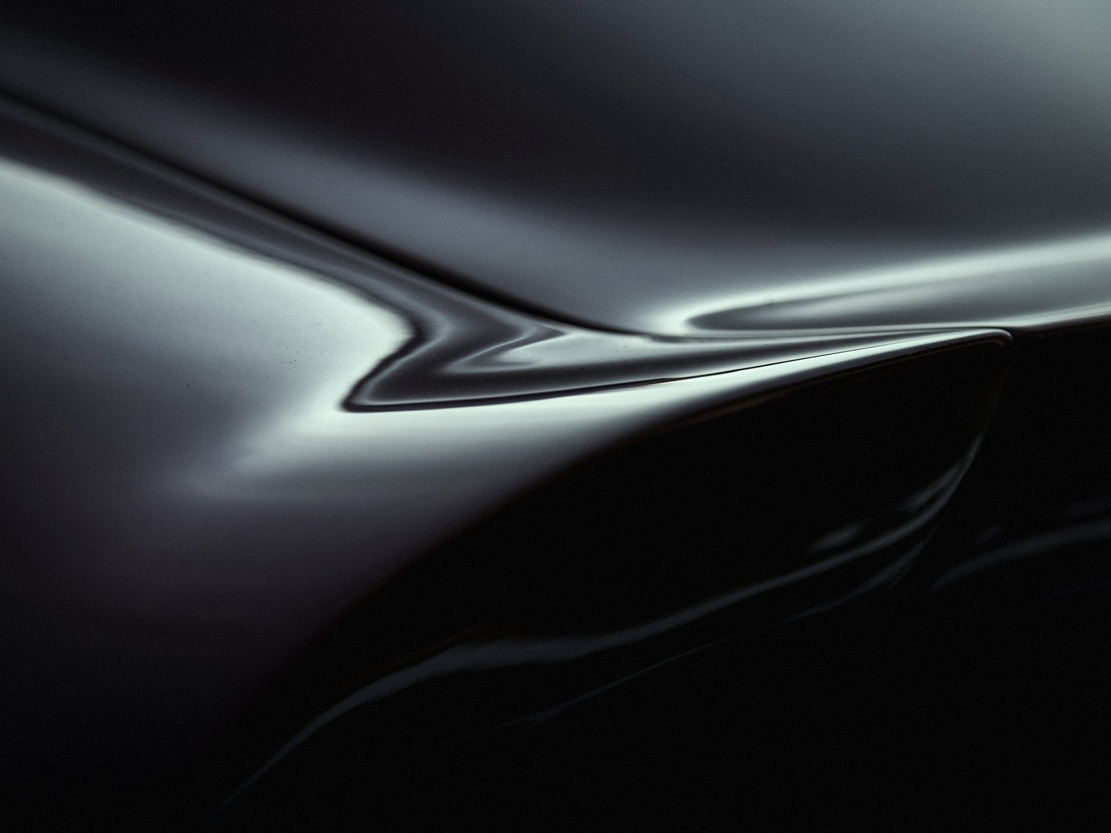 Mirror-gloss dark panel reflecting a single light bar